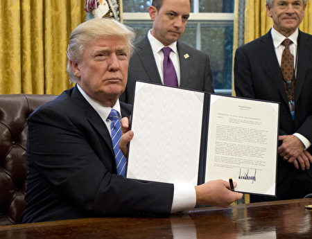 川普向在場記者展示退出TPP的行政令。(Ron Sachs - Pool/Getty Images)