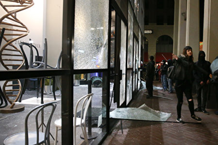 Chase银行遭到抗议者的破坏，一女子禁止人们拍照。(Elijah Nouvelage/Getty Images)