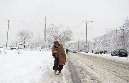 An Afghan man makes his way down a snow covered street in Kabul on February 5, 2017. Avalanches and freezing weather have killed more than 20 people in different areas of Afghanistan, officials said on February 4, as rescuers worked to save scores still trapped under the snow. / AFP / SHAH MARAI        (Photo credit should read SHAH MARAI/AFP/Getty Images)